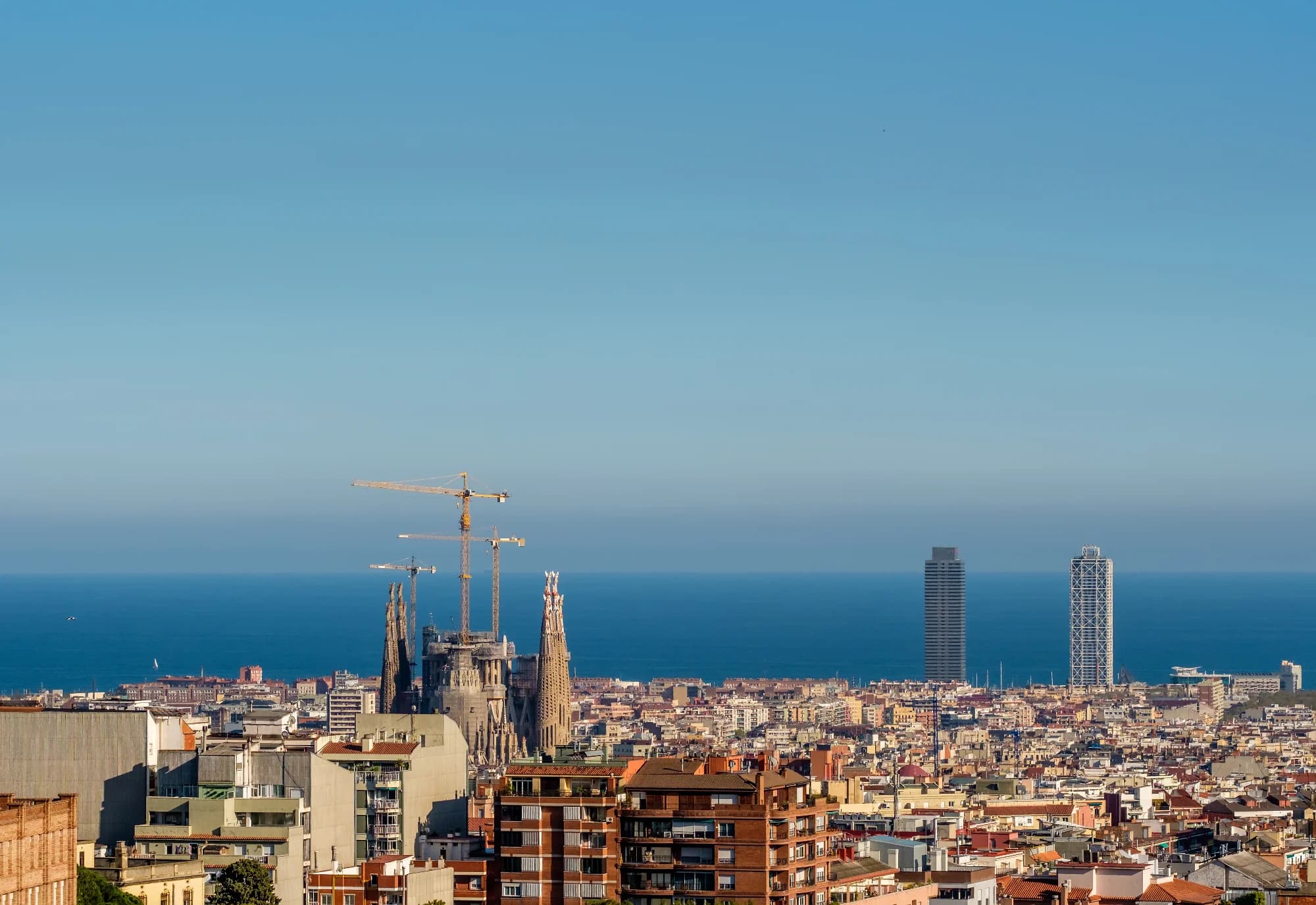 Vista soleada de los tejados de Barcelona y el Mediterráneo desde una terraza